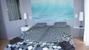 A bedroom with a large bed, two bedside tables, a window with curtains, and a wall painting of a wave. - Modern, Family Friendly & Peaceful Villa with 15m long Infinite Private Pool & J (Theologos, Malesina)