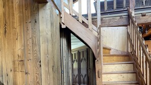 A wooden staircase leading to a second floor with a view of a room with wooden walls and a window. - Savoyard Chalet Authentic (Saint-Martin de Belleville)