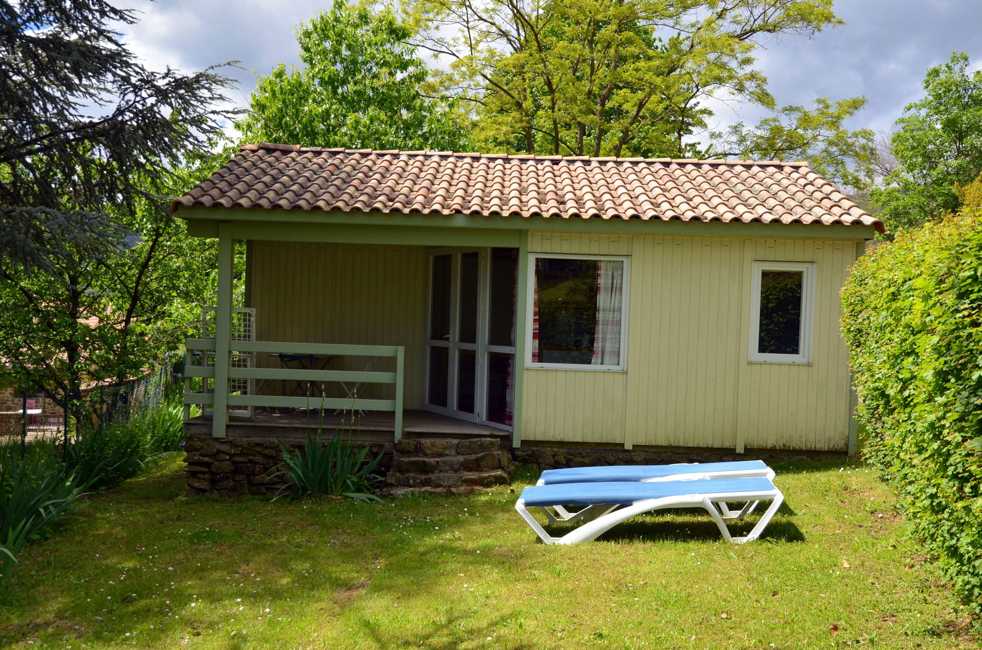 A small, single-story building with a tiled roof, a front porch, and a small window.