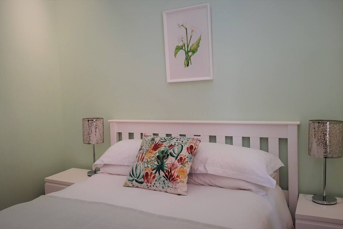Ein Schlafzimmer mit einem Bett, zwei Nachttischen und zwei Wandlampen.