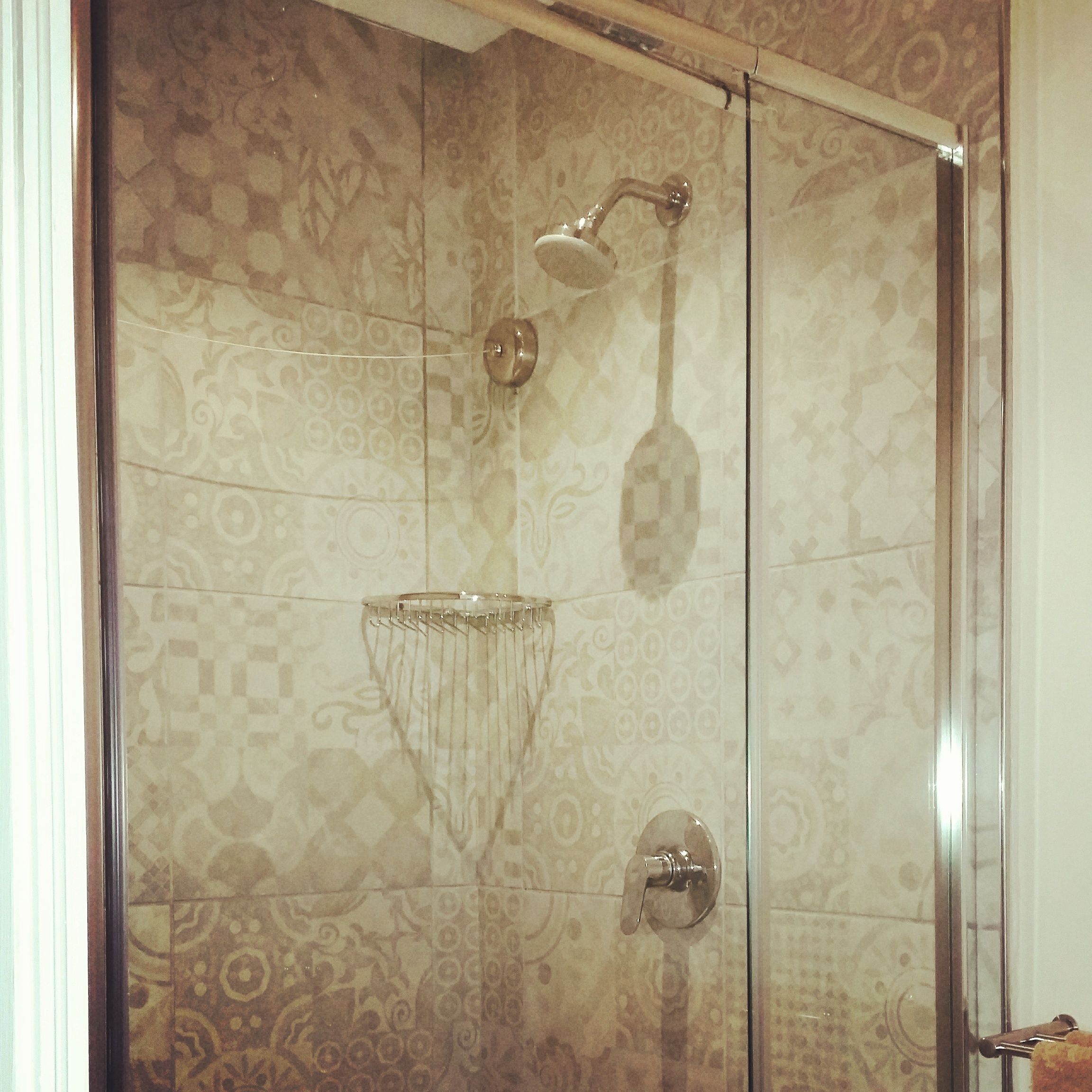 Une douche avec une porte en verre et un pommeau de douche.
