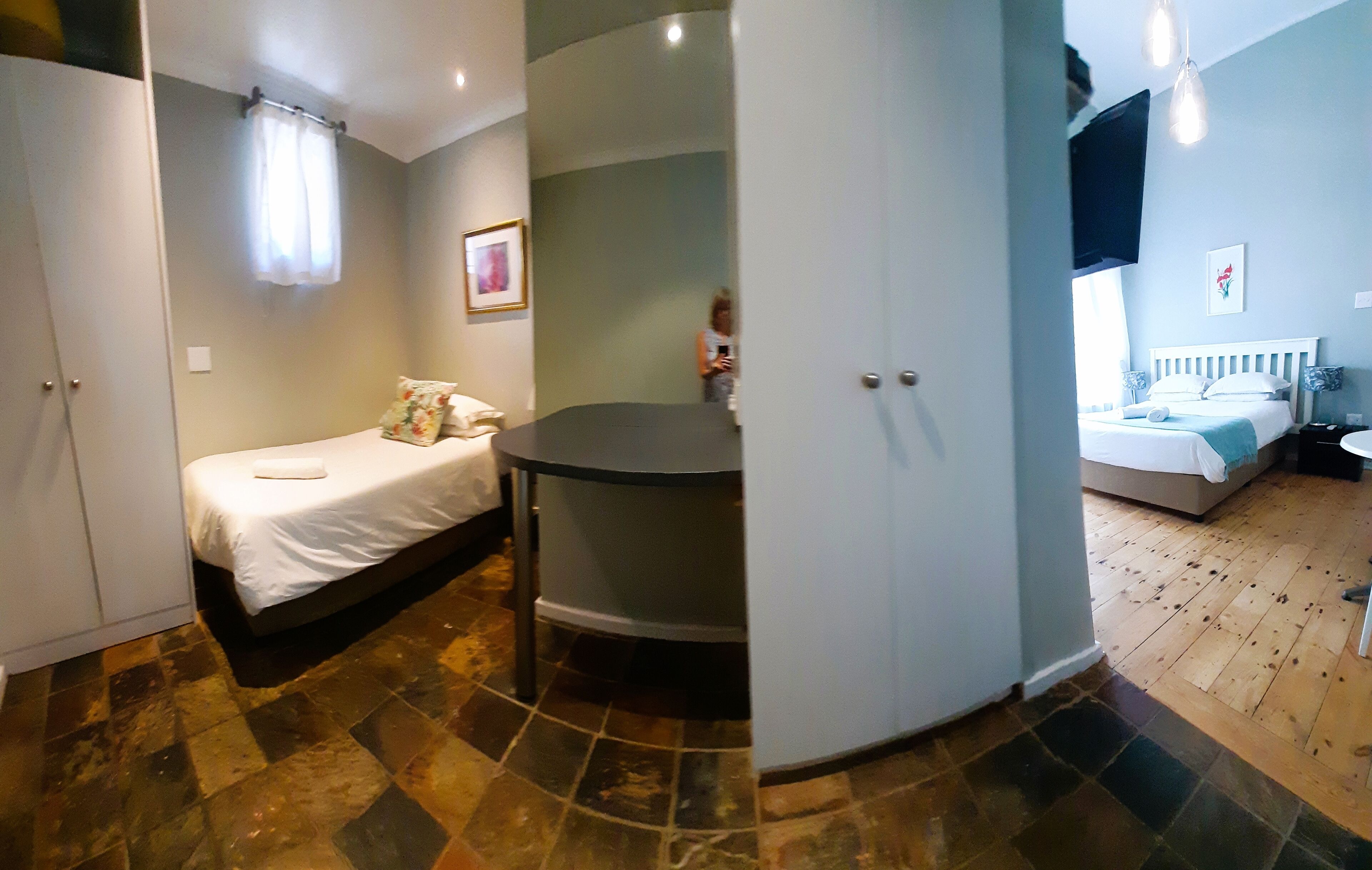 Ein kleines Hotelzimmer mit einem Bett, einem Tisch und einem Stuhl.