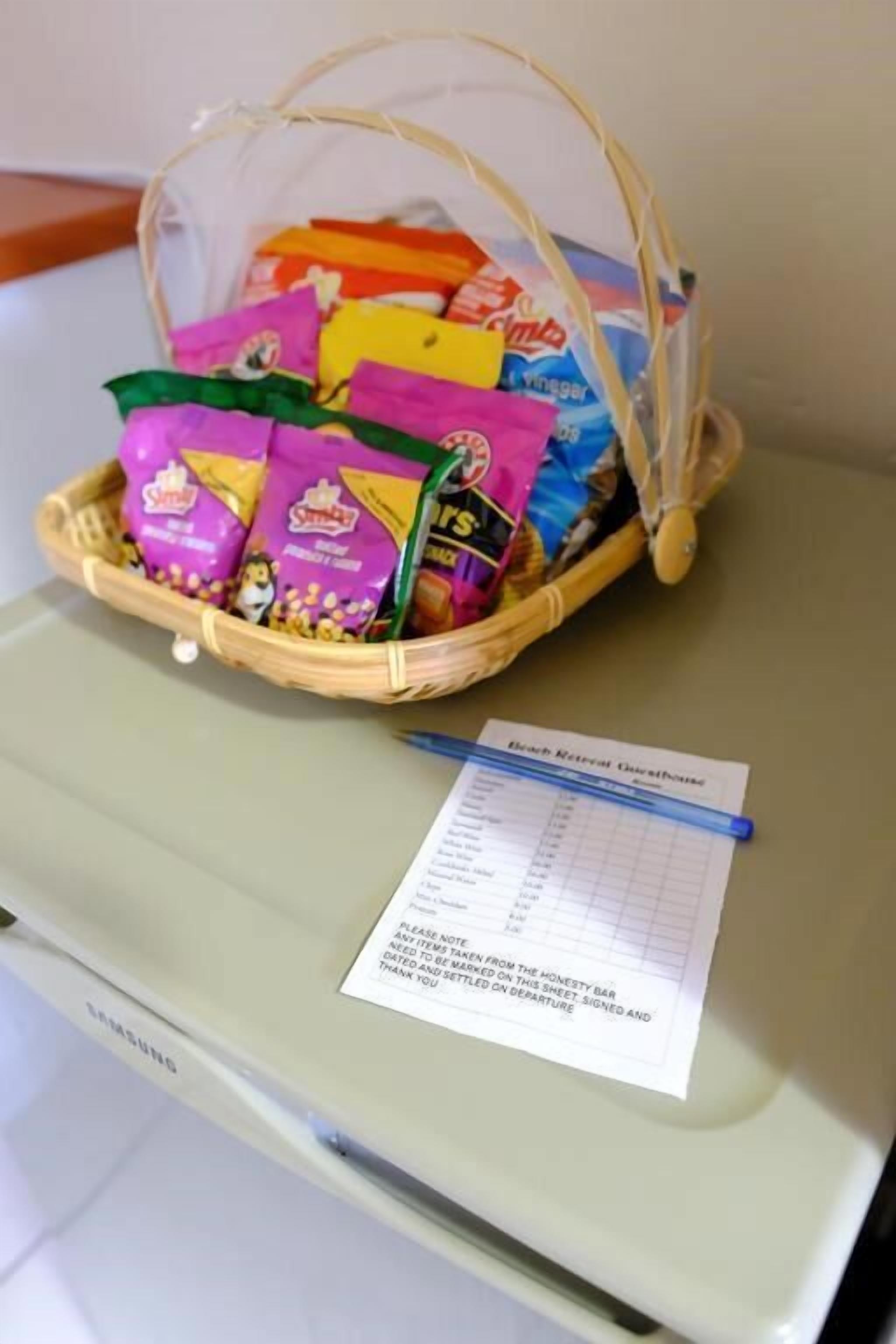 Un refrigerador Samsung con una cesta de bocadillos y un letrero de casa de huéspedes.