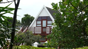 A house with a triangular roof, a balcony, and surrounded by greenery. - Aberdour Guesthouse (Gqeberha (Port Elizabeth))