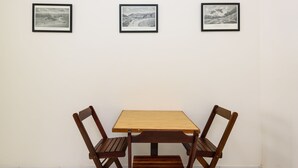 A dining area with a wooden table and four chairs, three framed black and white photographs on the wall. - Omar do Rio - A1208 (Rio de Janeiro)