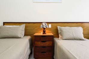 A double bed with a wooden headboard, two bedside tables with lamps, and a small drawer unit. - Omar do Rio - A1208 (Rio de Janeiro)