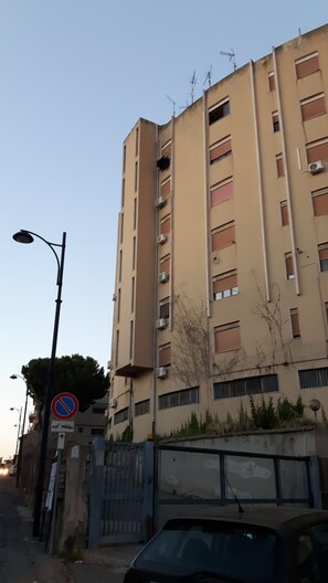 A multi-story residential building with a no parking sign, a street lamp, and a gated entrance. - Affittacamere da chris (Reggio Calabria)