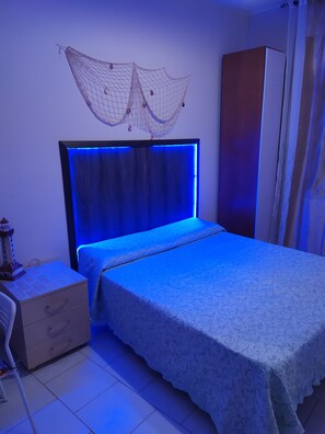 A bedroom with a bed, a nightstand, a wardrobe, and a decorative hanging net. - Affittacamere da chris (Reggio Calabria)