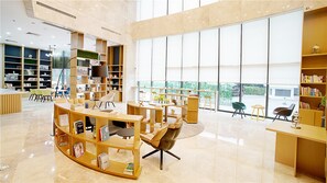 A modern library with bookshelves, seating areas, and large windows. - Atour Hotel Yueqiao Guangzhou (Guangzhou)