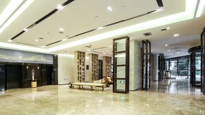 A modern lobby with a marble floor, a central bench, and a large glass door leading to a staircase. - Atour S Hotel Chunxi Road Chengdu (Chengdu)