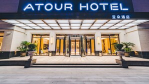 The exterior of Atour Hotel with a revolving door entrance, potted plants, and a well-lit facade. - Atour Hotel Wuhou Temple Chengdu (Chengdu)