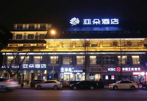 A hotel with a prominent sign, multiple floors, and parked cars in front. - Atour Hotel Dufu's Thatched Cottage Chengdu (Chengdu)