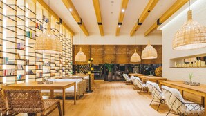 A modern library with wooden bookshelves, wicker furniture, and hanging lamps. - Atour Hotel Dufu's Thatched Cottage Chengdu (Chengdu)