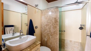 A bathroom with a sink, mirror, towel rack, and a shower area. - Omar do Rio - BR902 (Rio de Janeiro)