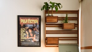 A room with a vintage-style desk, a framed movie poster, a Rolling Stones poster, a plant, and a vintage suitcase. - Omar do Rio - BR902 (Rio de Janeiro)