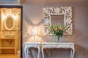 A bathroom with a sink, mirror, and vanity with a vase of flowers. - Hotel Jedlinka (Jedlina-Zdrój)