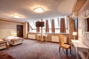 A hotel room with a bed, a chair, a desk, a TV, and a window with curtains.