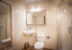 A bathroom with a toilet, sink, and shower.