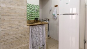 A kitchen with a white refrigerator, a sink, and a tiled backsplash. - Omar do Rio - PM408 (Rio de Janeiro)