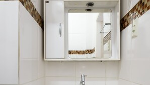 A compact bathroom with a white sink, a mirror, and a small cabinet with drawers. - Omar do Rio - PM408 (Rio de Janeiro)