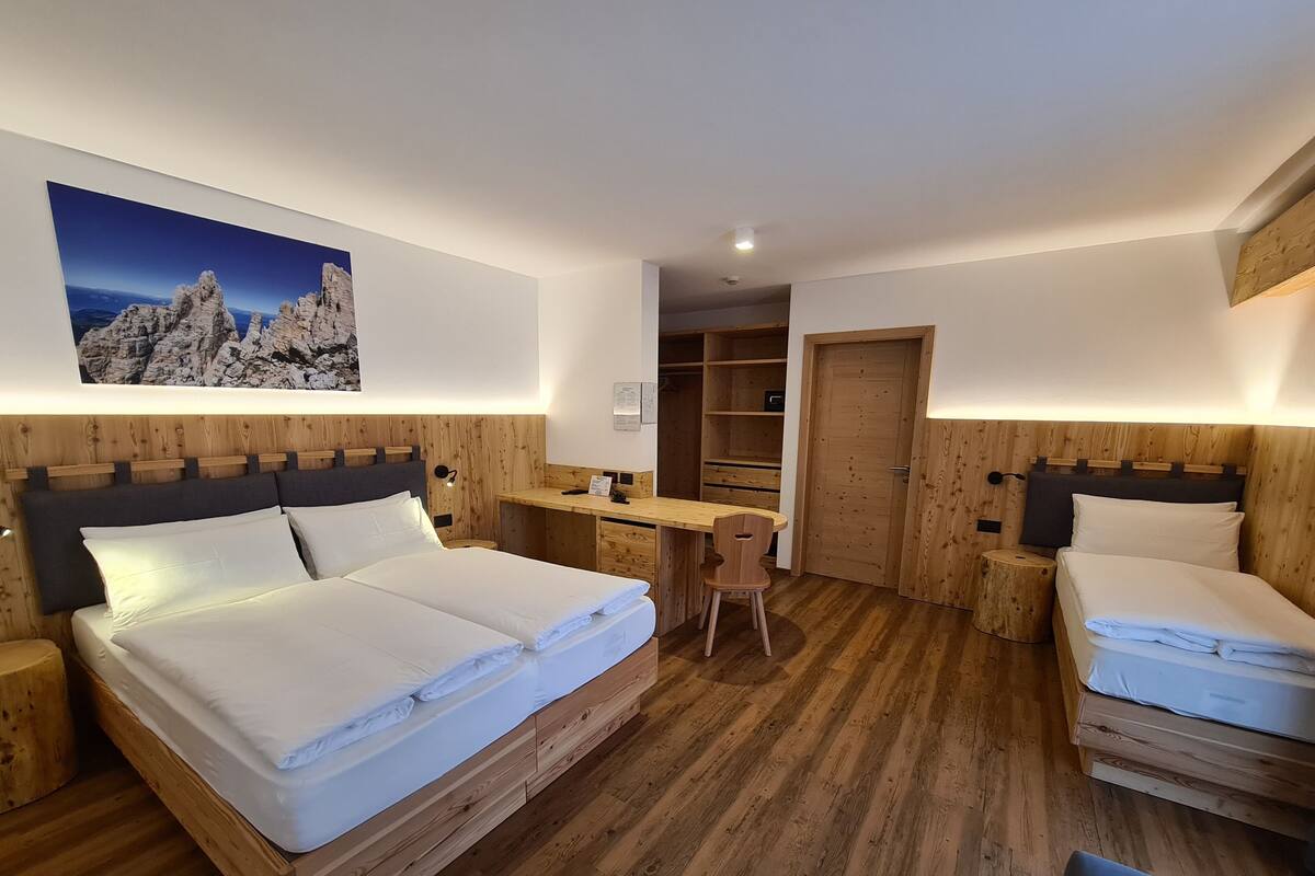 A bedroom with a wooden bed, a desk, and a chair.