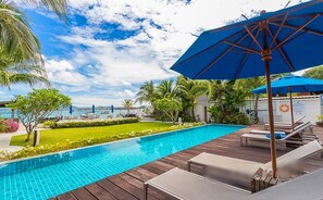 A pool area with a wooden deck, lounge chairs, and a blue umbrella. - Luxurious Seafront  2 brm Penthouse with Spectacular views / unique design  (Thalang)