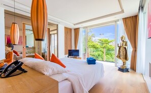 A modern hotel room with a large bed, a TV, and a statue by the window. - Luxurious Seafront  2 brm Penthouse with Spectacular views / unique design  (Thalang)