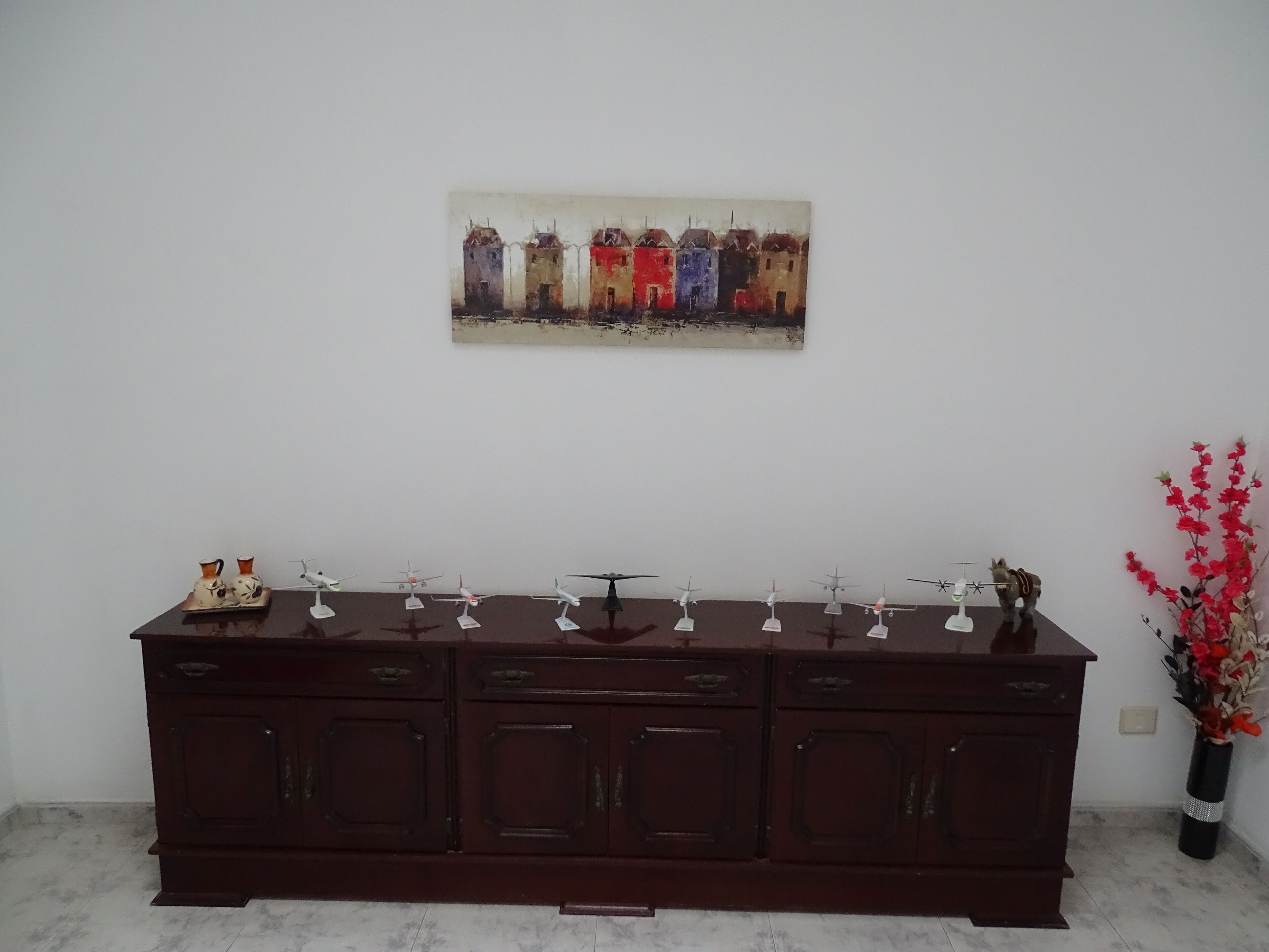 Un mueble de madera oscura con varios cajones y una pequeña repisa superior.