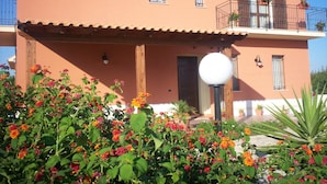 Un edificio de dos pisos con un balcón, una puerta y un accesorio de iluminación.