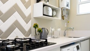 Eine moderne Küche mit Gasherd, Backofen, Mikrowelle und einer integrierten Waschmaschine.