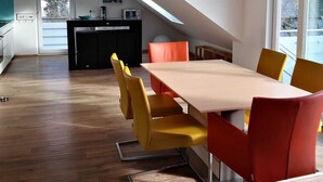 A modern kitchen with a microwave, a clock, and a window. - Fantastic, exclusive apartment with fantastic lake and alpine views (Immenstaad am Bodensee)