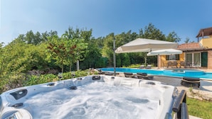 A hot tub with a control panel, a pool with lounge chairs, and a patio umbrella. - Quiet holiday house with large pool on the outskirts of Rezanci (Rezanci)