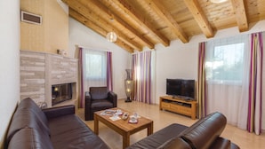 A living room with a fireplace, leather sofas, a TV, and striped curtains. - Quiet holiday house with large pool on the outskirts of Rezanci (Rezanci)
