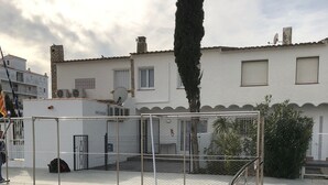 A swimming pool with a metal fence, a water slide, and a stone-lined edge. - House on port with garden-Mooring possible-Santa Margarida Rosas (Roses)