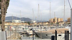 A marina with multiple boats docked, a clear sky, and buildings in the background. - House on port with garden-Mooring possible-Santa Margarida Rosas (Roses)