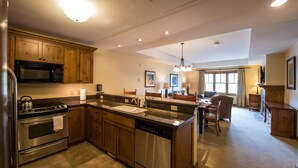 A kitchen with wooden cabinets, stainless steel appliances, and a central island. - Near the Slopes! Bright, Modern Condo | Fireplace (Crested Butte)