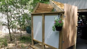 A wooden greenhouse structure with a slanted roof and a door. - Treehouse OBX. Cozy cottage in family/pet-friendly neighborhood. Close to sound. (Kill Devil Hills)