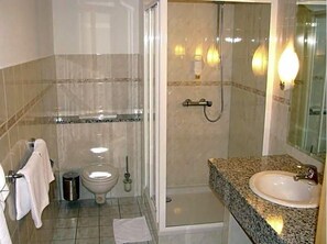 A bathroom with a shower, toilet, and sink. - Hotel am Platz (Hohenmoelsen)