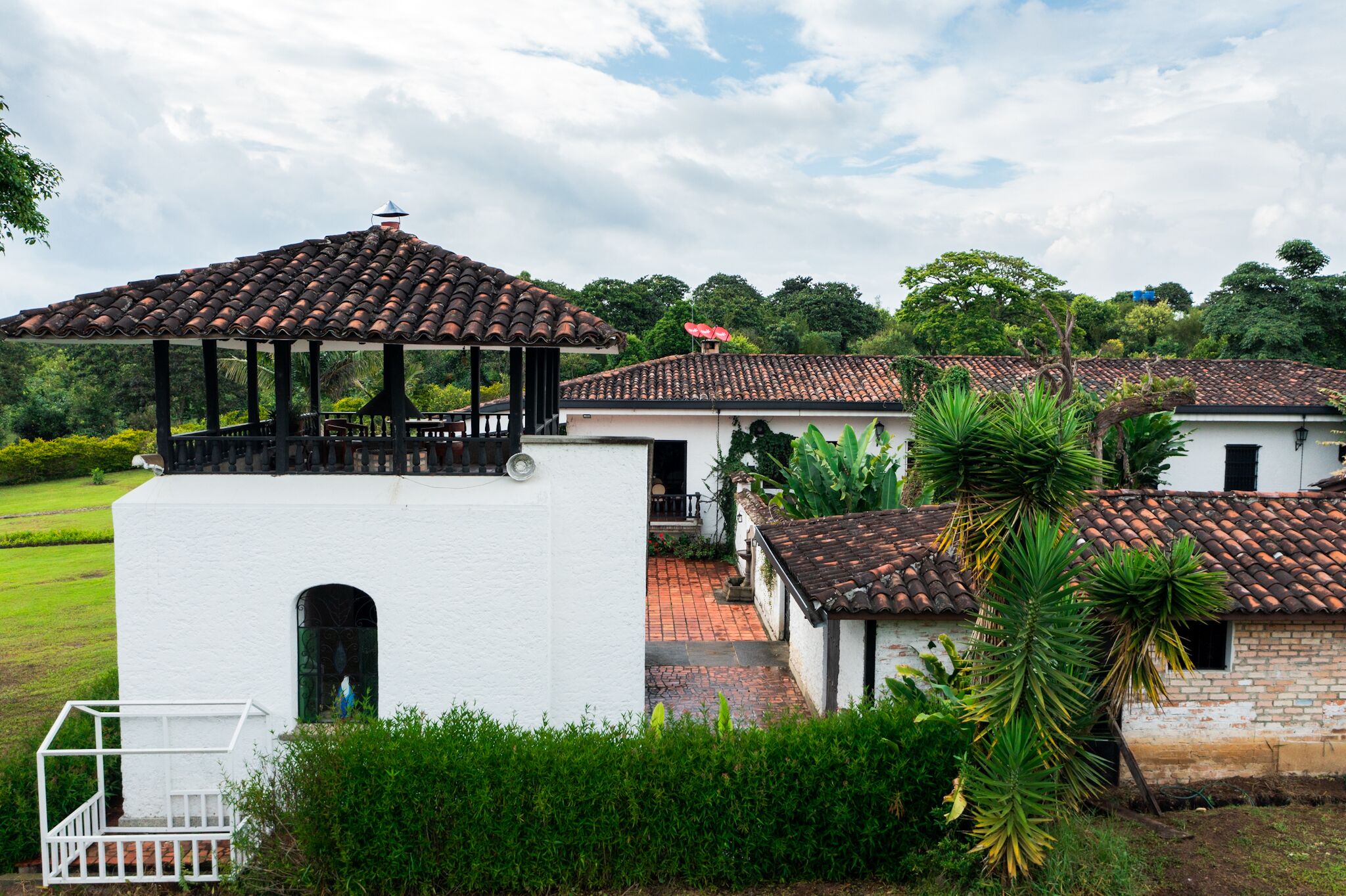 A white building with a tiled roof and a balcony.