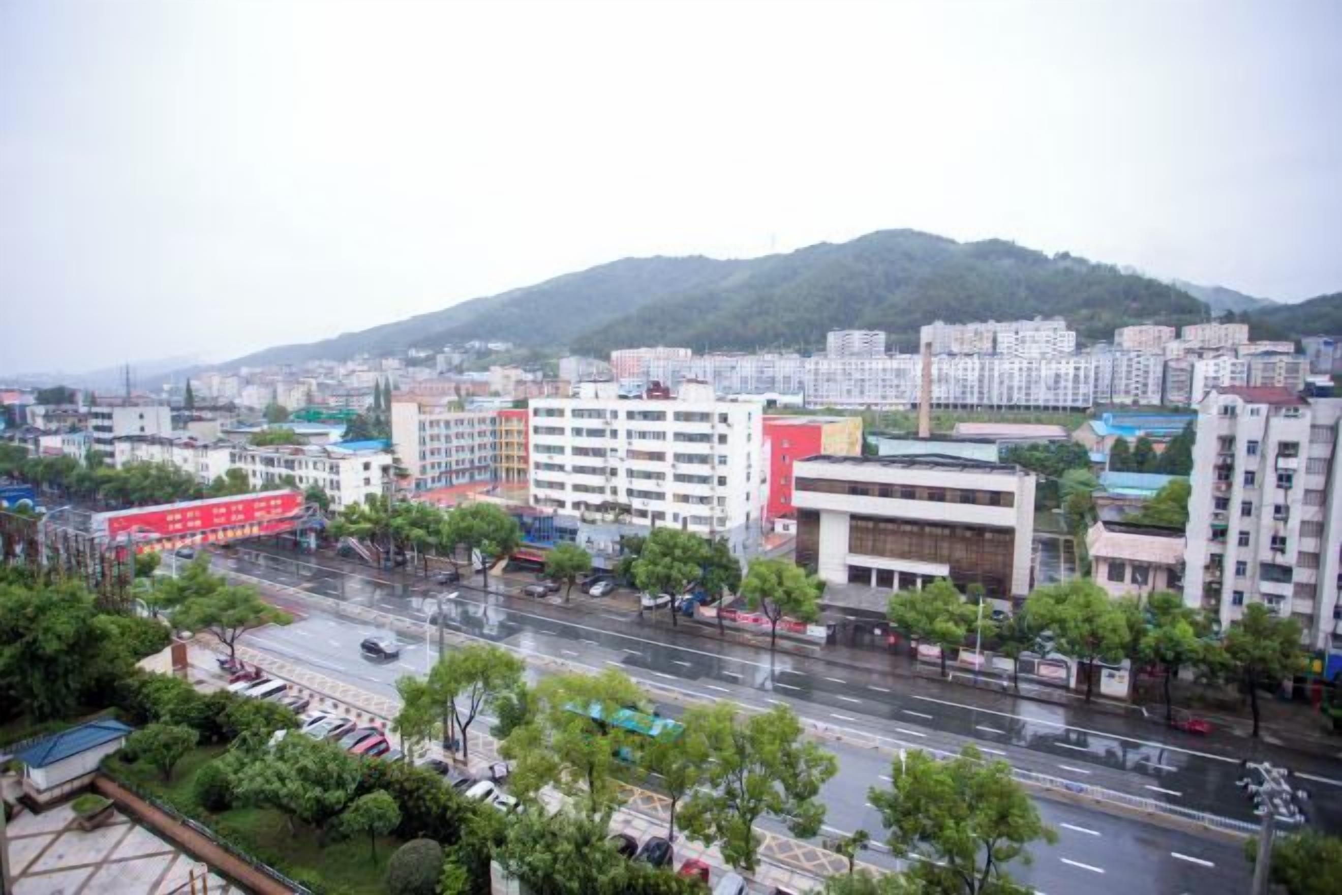 A cityscape with buildings, roads, and a mountain in the background.
