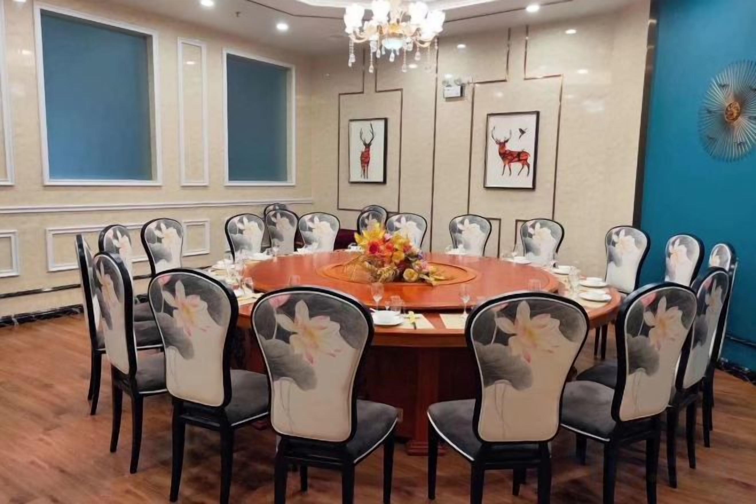 A conference room with a round table, chairs, and a chandelier.