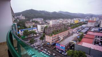 A cityscape with buildings, roads, and a mountainous backdrop.