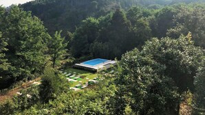 A resort with a pool surrounded by lush greenery and hills in the background. - Villa Musolino Country Resort (Messina)