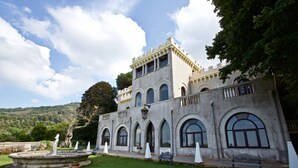 A historic building with arched windows and a courtyard with a fountain. - Villa Musolino Country Resort (Messina)
