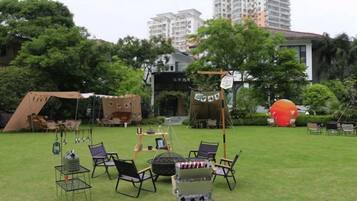 An outdoor seating area with tables and chairs, a tent, and a large inflatable structure.