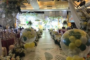 Un pasillo decorado con motivos florales y globos, que conduce a una zona de estar.