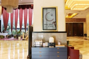 A hotel lobby with a reception desk, a framed clock, and a check-in counter. - Sanhe Grand New Century Hotel Pingyang (Pingyang)