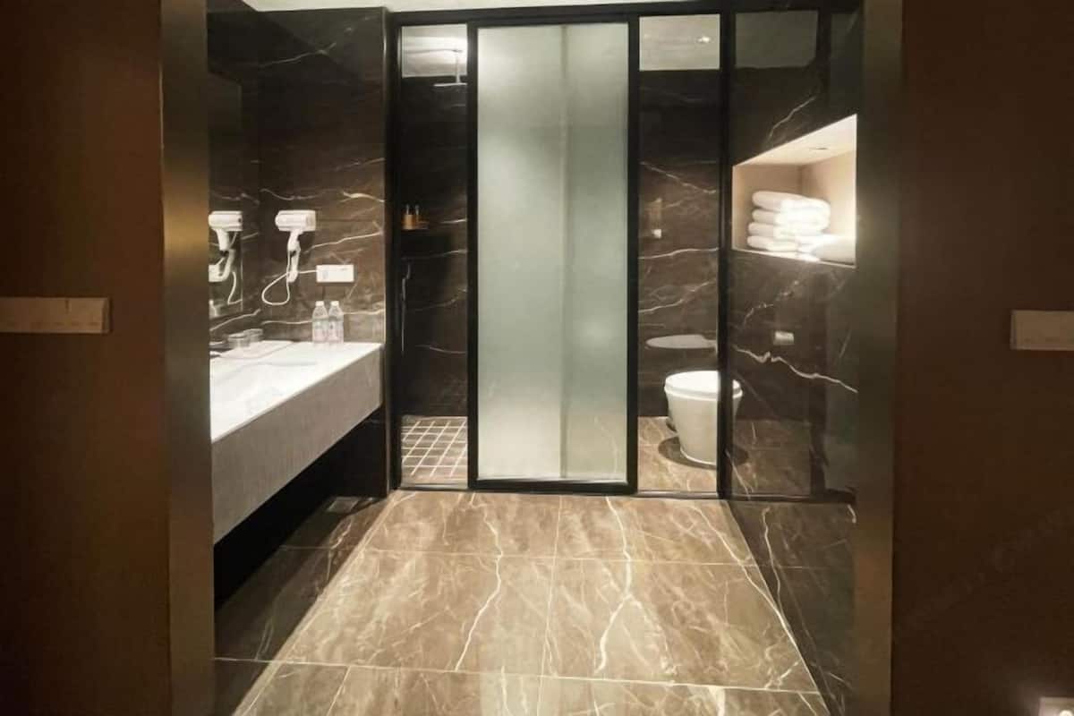Un bagno moderno con cabina doccia in vetro, un mobile lavabo con specchio e il water.