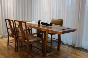 Zona pranzo con tavolo in legno, sedie e una panca.