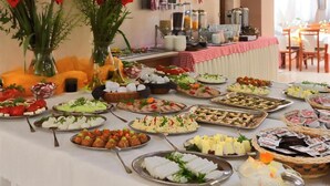 Una mesa de buffet con diversos platos y una estación de café al fondo.